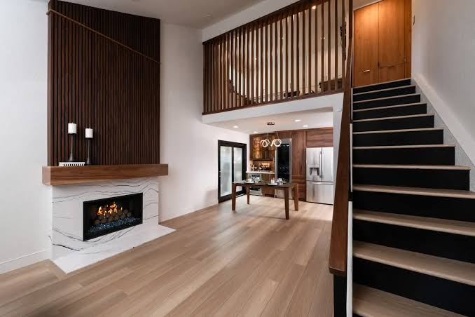 Staircase and stone fireplace with slatted wood wall