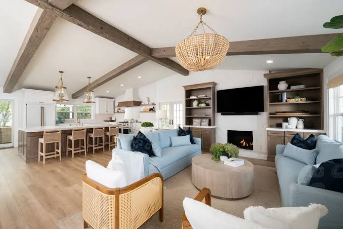 Open living room with blue sofas and a beaded chandelier